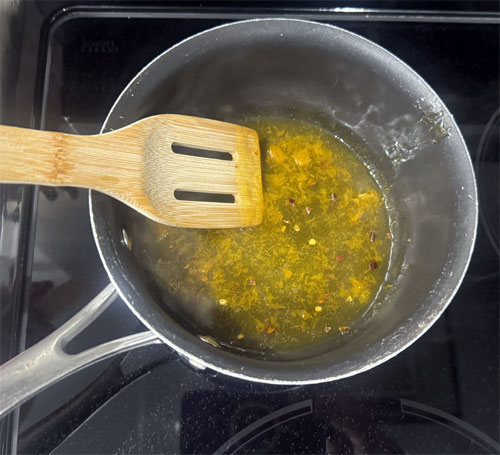 While the shrimp are cooking, put the last three ingredients, preserves, cider vinegar, and red pepper flakes, in a saucepan. Cook and stir on medium-low heat until the preserves are melted.