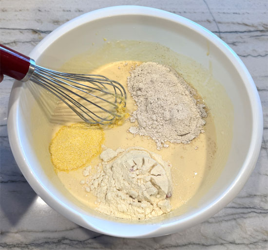 Add the oat flour, cornmeal, and protein powder. Whisk until fully combined.