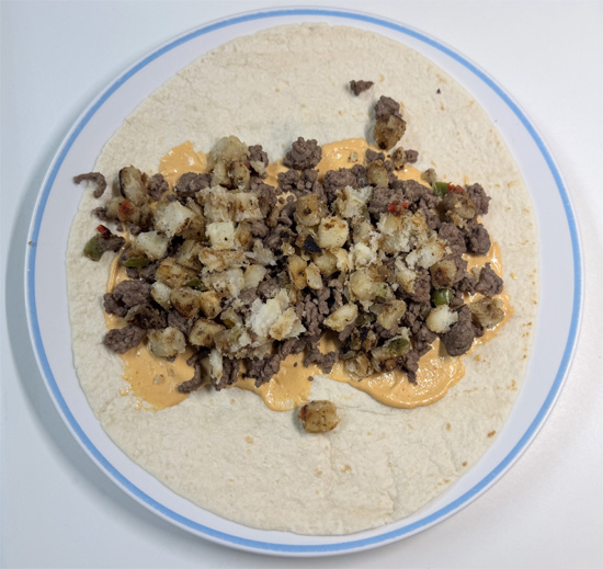 Evenly divide the beef (about 3/4 cup per burrito), potatoes (about 1/2 cup), and eggs (about 1/3 cup) among the tortillas.