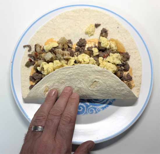 Fold up the bottom of the tortilla, then fold in the sides, and roll tightly.