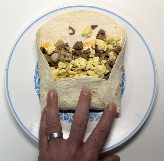 Fold up the bottom of the tortilla, then fold in the sides, and roll tightly.