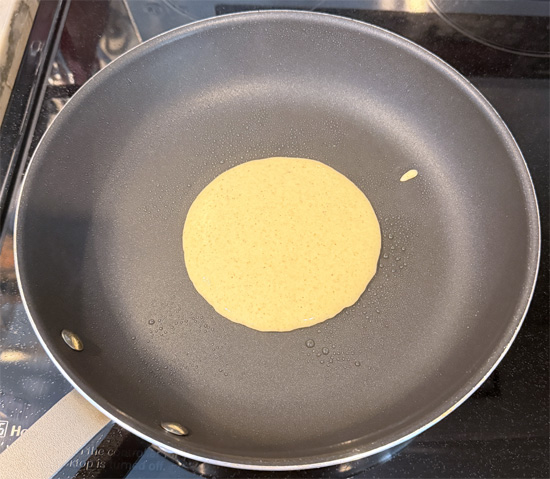 Heat a nonstick pan over medium-low heat. Lightly coat with olive oil spray. Pour 1/4 cup of batter into the pan for each pancake.