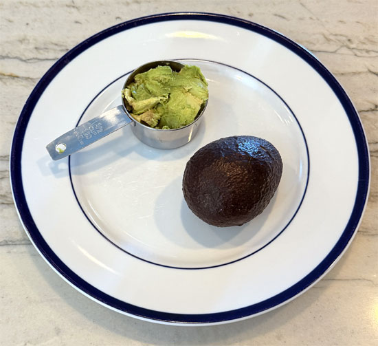 Cut the avocado in half and remove the pit. Then scoop out the filling and put it in a bowl. 
