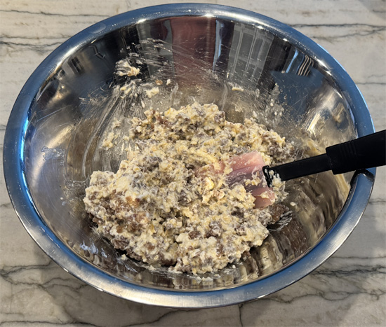 While crust bakes, cook sausage in a non-stick pan over medium-high heat for 5-7 minutes until lightly browned. Transfer sausage to the cheese mixture and stir to combine. Reserve the grease in the pan.
