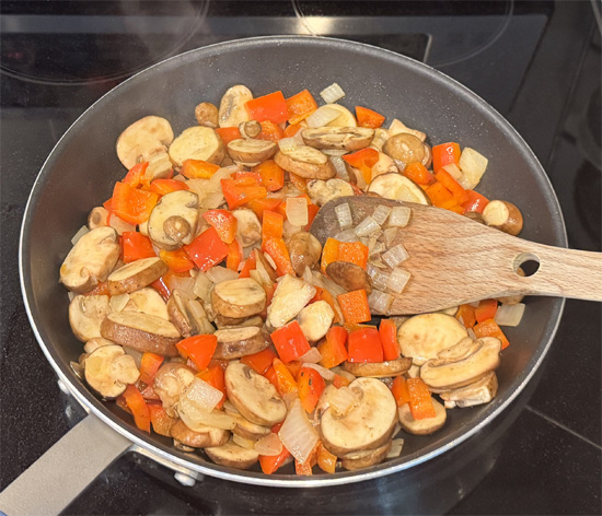 Using the same pan with reserved grease, cook onions for 3-4 minutes. Add bell peppers and cook 3-4 more minutes. Add mushrooms and cook final 2-3 minutes.