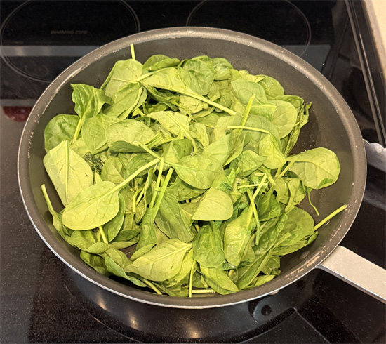 Heat a large skillet over medium heat and spray lightly with olive oil. Cook the spinach in batches until wilted. Transfer to a bowl and set aside.