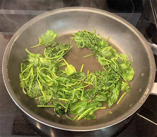 Heat a large skillet over medium heat and spray lightly with olive oil. Cook the spinach in batches until wilted. Transfer to a bowl and set aside.