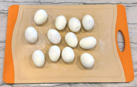 Once the eggs are cooled, gently tap them on a hard surface to crack the shell, then peel them. Running them under cold water while peeling can help remove stubborn bits of shell.