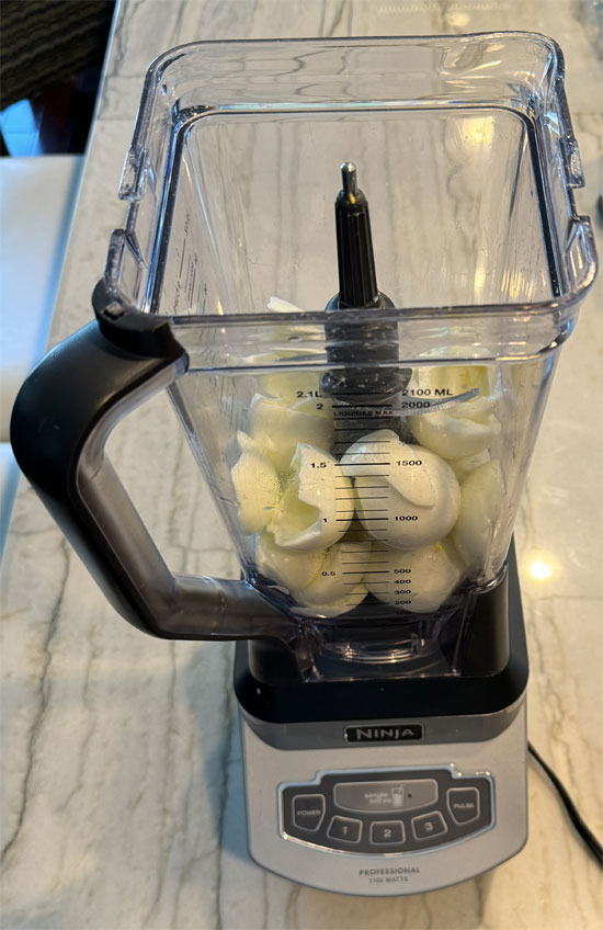 Put all the eggs (minus the yolks you removed) into a blender. Then, pour the milk and cocoa mixture over the top.