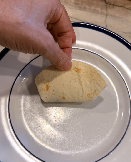 Spoon about 1/3 cup of filling onto each tortilla. Fold in the sides, then roll up tightly.
