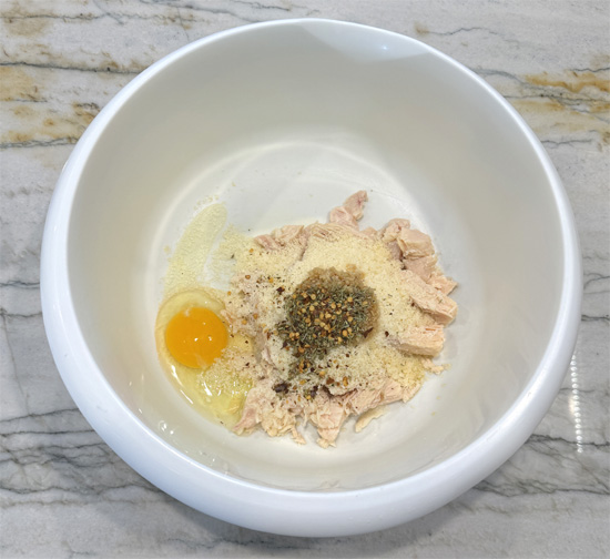 Mix together the first seven ingredients, chicken, parmesan, garlic, oregano, rosemary, red pepper and egg. Make sure it's thoroughly combined. 