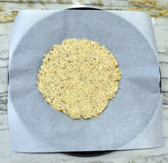 Spread the chicken crust mixture onto the parchment paper, about 10 inches across.
