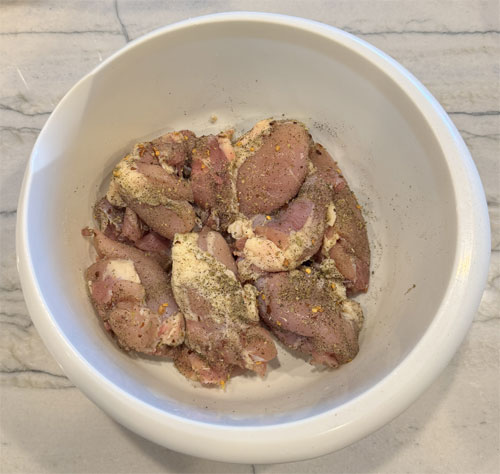 Place chicken in a bowl, season with one portion of the spice mix, covering all sides. For extra heat, add crushed red pepper.