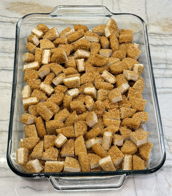 Arrange the cut nuggets on top of the waffles in an even layer. 