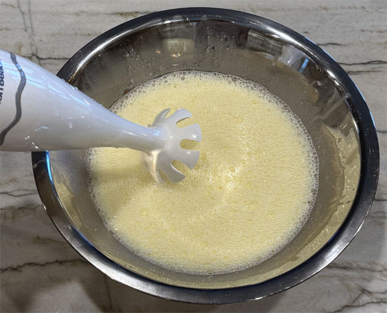 Whisk together the remaining six ingredients: half & half, egg whites, whole eggs, syrup, salt and cayenne pepper. Keep whisking until it turns a little frothy. We like using an immersion blender to speed things up and mix it well. 