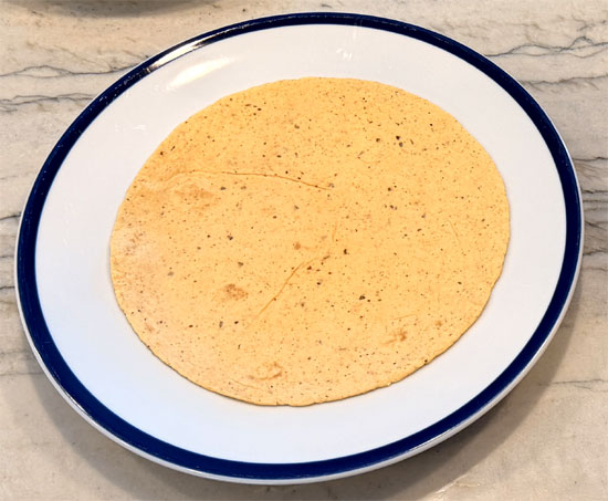 Lay out the tortillas and spread 2 Tbsp. of the enchilada mixture on each one. Wrap each tortilla around a hot dog and place it seam side down in the baking dish, on top of the beans.