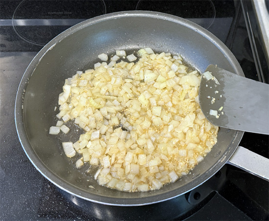 Add the chopped onions to the skillet with the bacon grease. Sauté on medium-high until the onions become translucent, about 3 minutes.