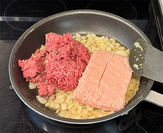 Add the ground turkey and ground beef into the pan with the onions. Cook over medium-high heat, breaking the meat apart, until browned and cooked through, about 5-6 minutes.