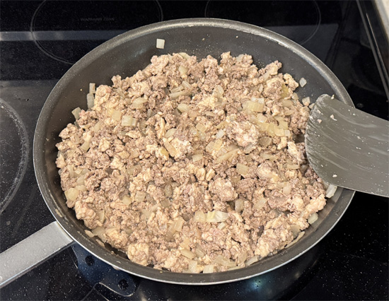 Add the ground turkey and ground beef into the pan with the onions. Cook over medium-high heat, breaking the meat apart, until browned and cooked through, about 5-6 minutes.