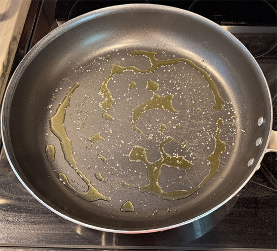 Sprinkle the salt over the oil, then layer the tomato slices and onion across the bottom of the pan. 