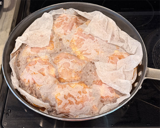 Wet a piece of parchment paper and place it over the chicken. Cover the pan with aluminum foil. 