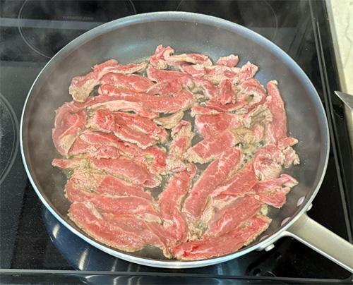 Heat the olive oil in a large skillet over medium-high heat. Working in batches, add the steak strips in a single layer. Cook about 1–2 minutes per side, just until browned. Transfer the browned steak to your slow cooker.