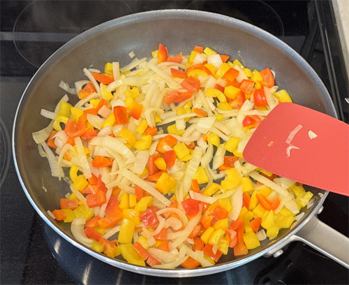 Use the same skillet and saute the bell peppers and onion. Cook for about 3-4 minutes until they soften, then add the minced garlic and cook for another 30 seconds. Pour all the ingredients into the slow cooker on top of the steak. 