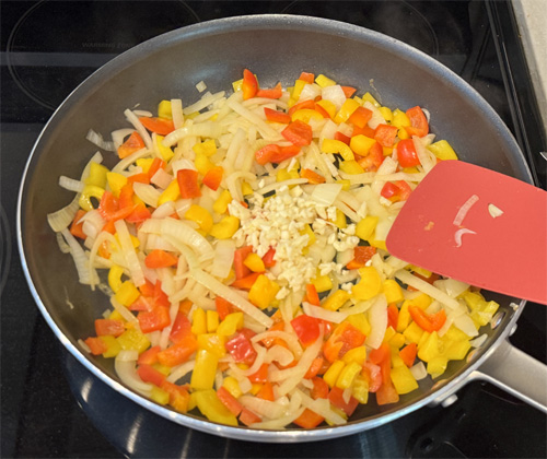 Use the same skillet and saute the bell peppers and onion. Cook for about 3-4 minutes until they soften, then add the minced garlic and cook for another 30 seconds. Pour all the ingredients into the slow cooker on top of the steak. 