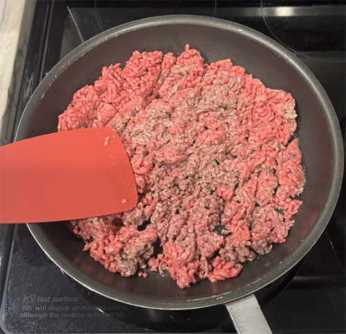 Then add the ground beef and cook. Keep stirring and breaking it up to brown everything evenly for about 8 minutes.