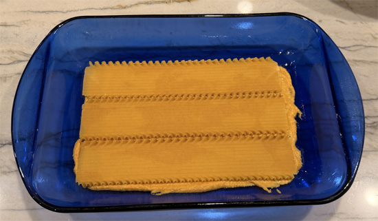 Spread 1 cup pumpkin sauce in bottom of prepared baking dish. Place 3 noodles across the pan (space between them is okay). 