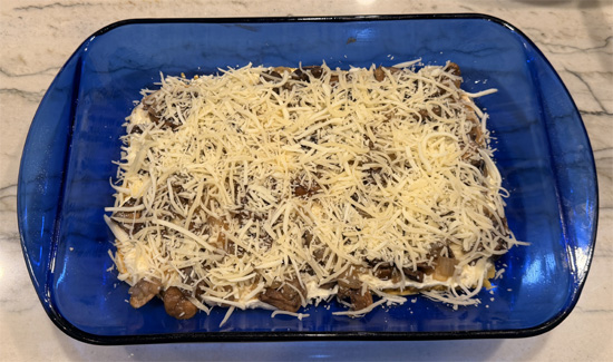 Spread half of the mushroom mixture over ricotta and sprinkle with 1 cup of the cheese mixture. 