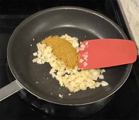 Add the bowl of spices to the onion mixture and stir together for another minute. 