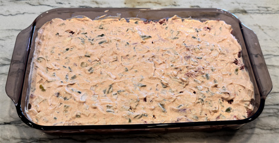 Layer the drained sauerkraut over the bread, then spread the chopped pastrami, followed by the sour cream mixture, then the mozzarella and finally the Swiss cheese over top. 