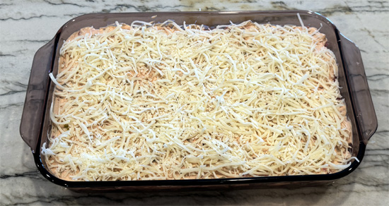 Layer the drained sauerkraut over the bread, then spread the chopped pastrami, followed by the sour cream mixture, then the mozzarella and finally the Swiss cheese over top. 