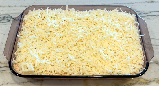 Layer the drained sauerkraut over the bread, then spread the chopped pastrami, followed by the sour cream mixture, then the mozzarella and finally the Swiss cheese over top. 