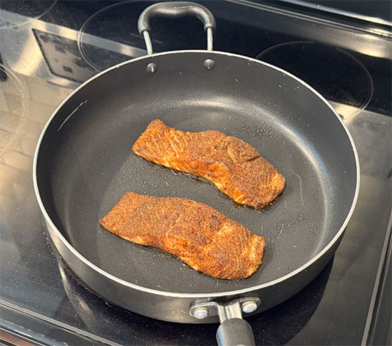 Heat a skillet over medium-high heat. Lightly coat the pan with olive oil spray and cook the salmon for 3-4 minutes per side, until it flakes easily with a fork. Remove from the heat and let it rest for about 3-4 minutes.