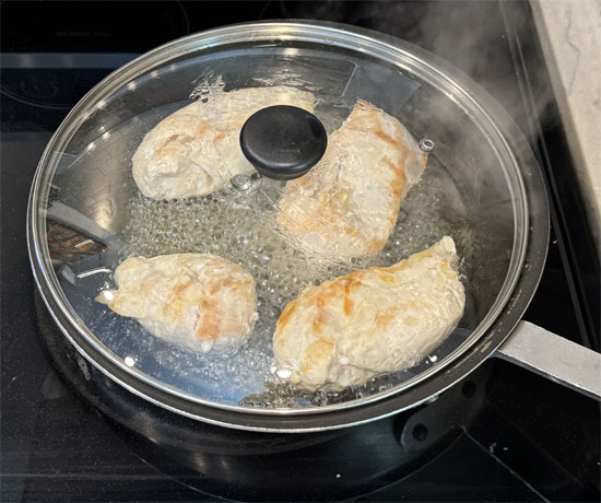 Flip the chicken breasts over, reduce the heat to medium and add 1/3 cup of chicken broth. Cover and cook for another 6-8 minutes until done. It's best to use a meat thermometer and make sure the internal temperature has reached 165 degrees Fahrenheit. 