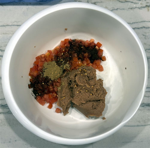 In a large bowl, mix together the refried beans, diced tomatoes, chili powder, ground cumin, and crushed red pepper flakes (if using). 