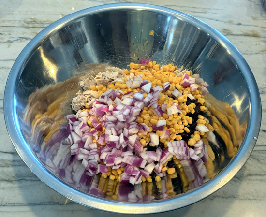 Place the chicken, black beans, corn, red onion, bell peppers and cilantro in a large mixing bowl.