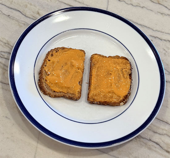 Spread the sriracha mayo evenly across both slices of toast. Top with the tomatoes and enjoy.