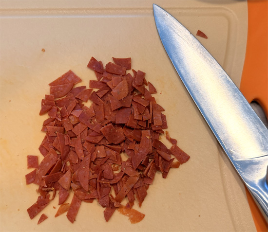 Add the garlic, half of the pepperoni slices chopped, Italian seasoning and red pepper flakes. Stir constantly for 1 minute.
