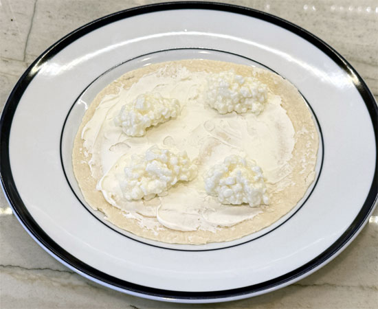 Spread the fat-free cottage cheese evenly over the cream cheese.