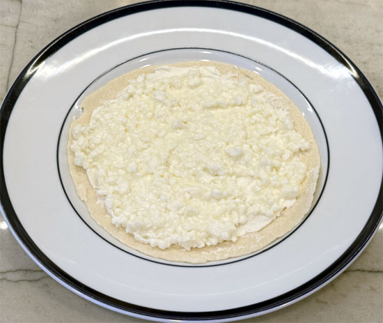 Spread the fat-free cottage cheese evenly over the cream cheese.