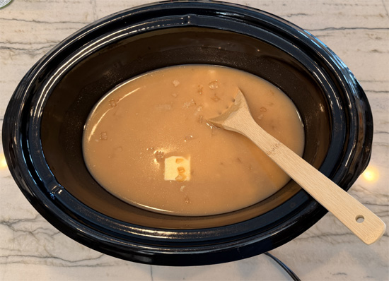 Place the chicken, condensed soup, onion and butter in a large slow cooker. Add the bone broth to cover and stir well. 