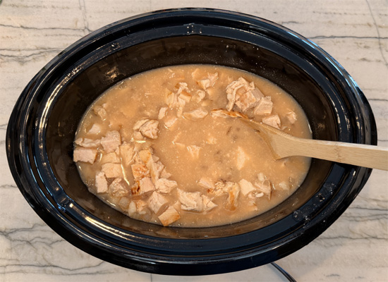 Place the chicken, condensed soup, onion and butter in a large slow cooker. Add the bone broth to cover and stir well. 