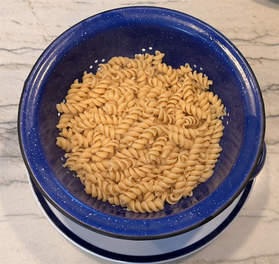 Drain the pasta in a colander, rinse with warm water, and set aside.