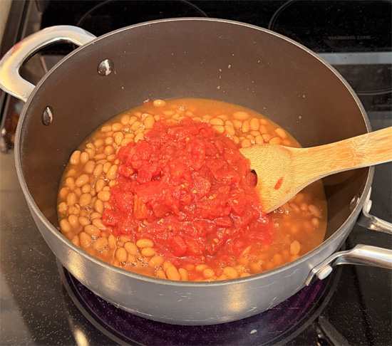 Return the empty pot to medium heat. Add the beans and tomatoes and heat about 3 minutes, until steaming.