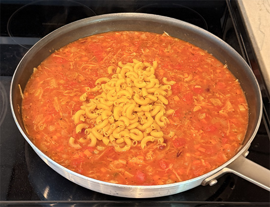 Mix in the macaroni, raise heat to medium and cook for an additional 12-15 minutes, until macaroni is done and vegetables are tender. 