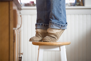 Are you taking foolish risks? - (Person standing on a stool with slippers on.)